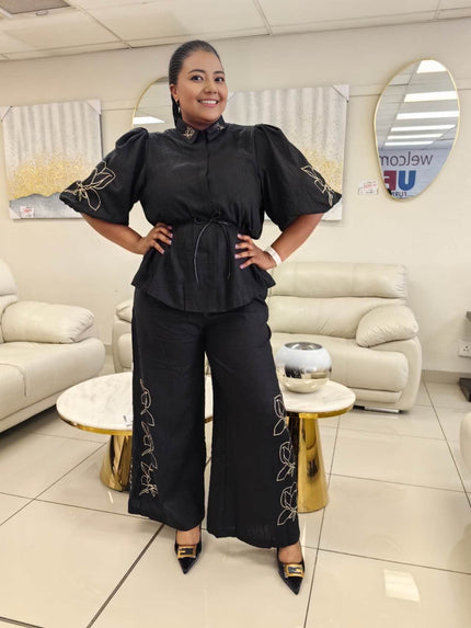 Black blouse with tie waist and puff sleeves paired with wide-leg floral pants
