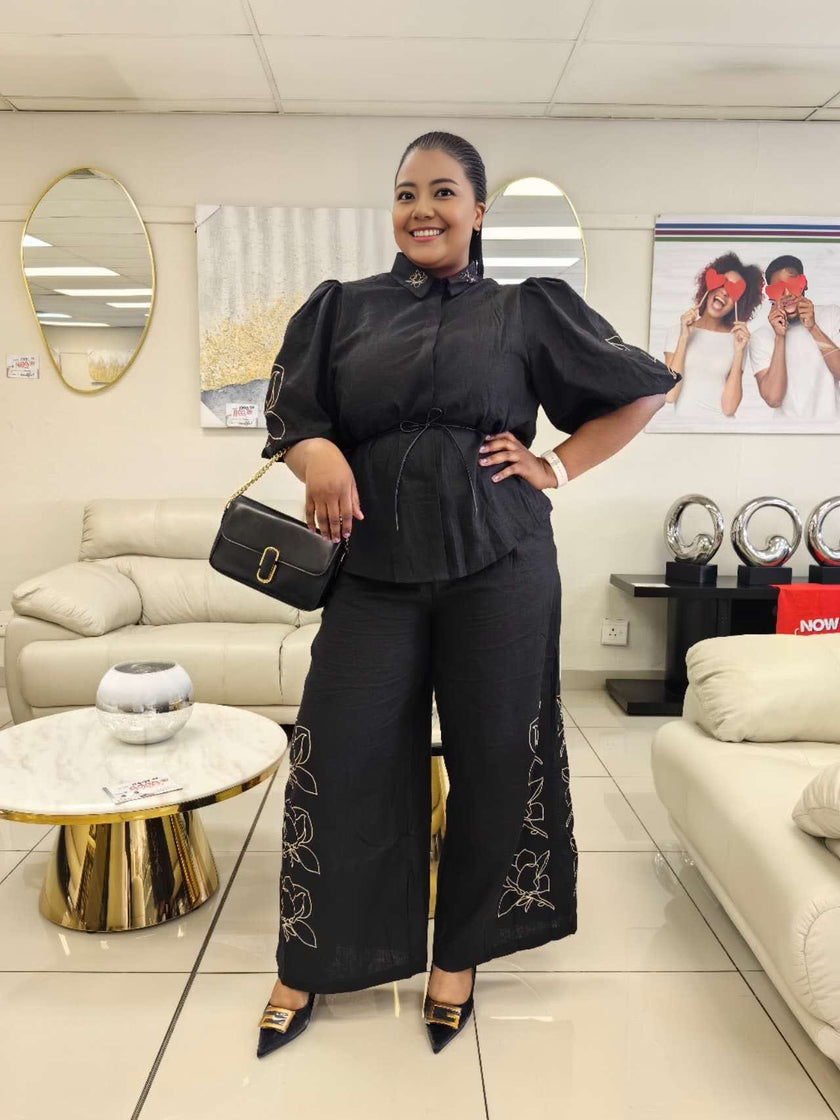 Black puff-sleeve top and wide-leg pants with embroidered floral accents