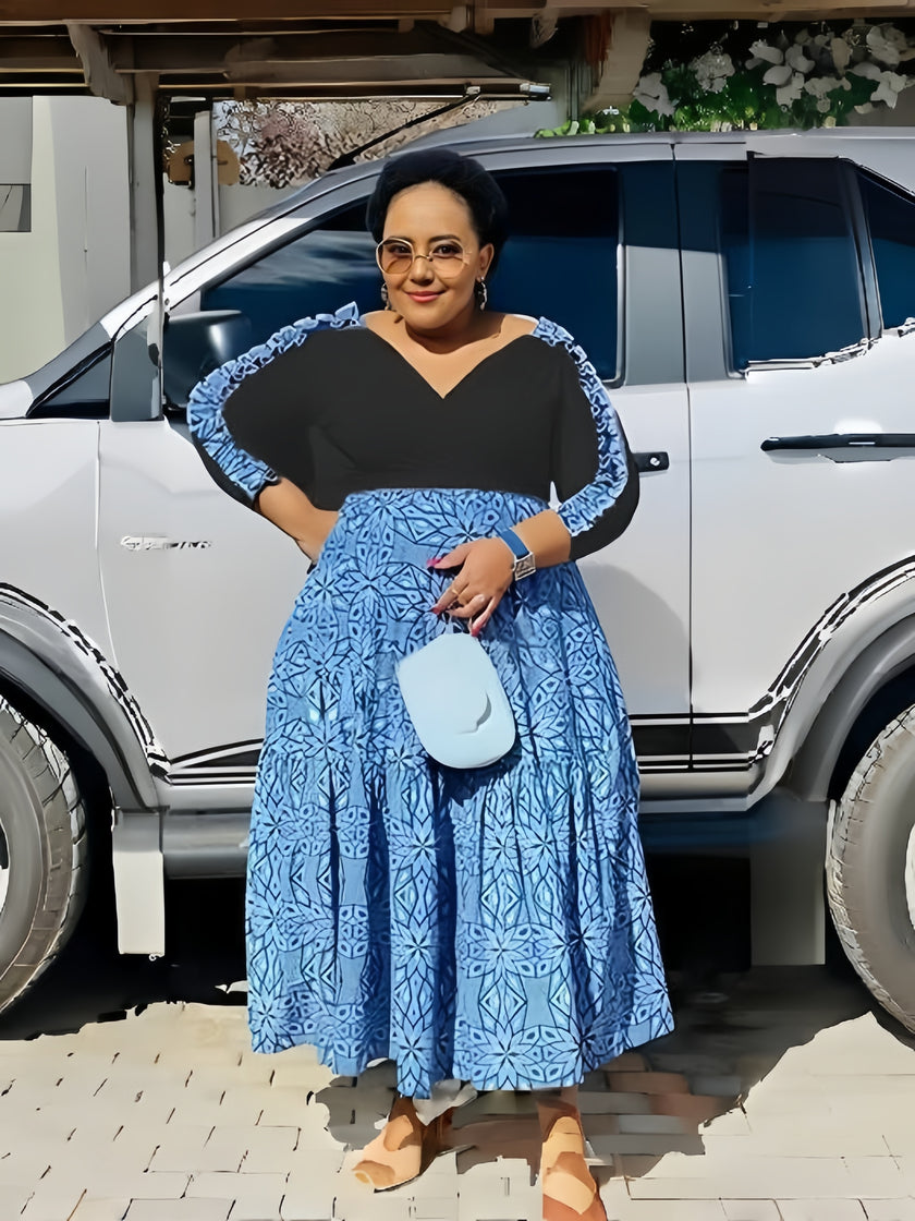 V-neck midi dress with dark bodice and blue geometric patchwork skirt