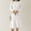 White ribbed knit midi dress with long sleeves and pearl buttons.